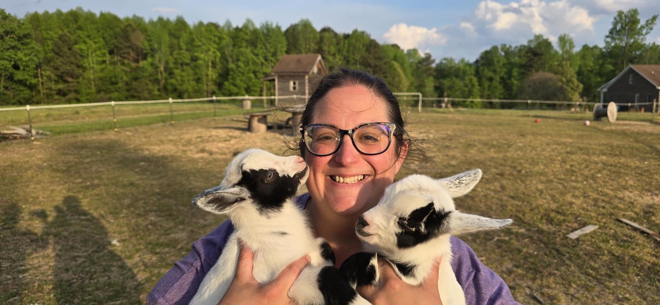 Andrea holding twin baby goats born at When Goats Fly